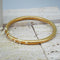 Close-up of gold golf bangle - waterproof jewellery by indie and harper 