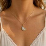woman wearing gold necklace with large crescent shaped moonstone pendant