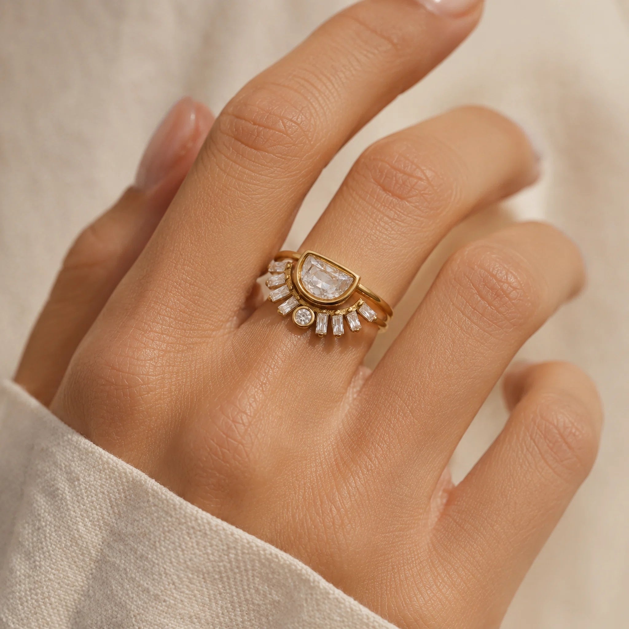 Waterproof gold double-band statement ring worn on hand, featuring a bezel-set half-moon cubic zirconia center stone with radiating baguette CZ accents and one round CZ detail.