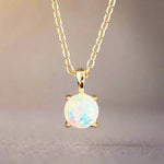 Gold necklace with a round opal pendant on a soft fabric background
