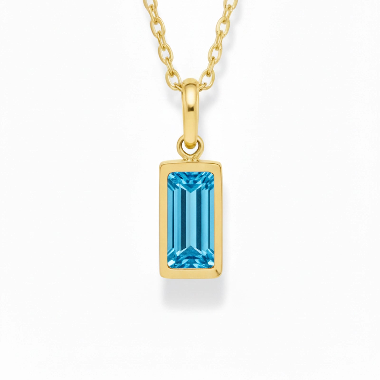 gold december birthstone necklace with blue cubic zirconia on a white background.