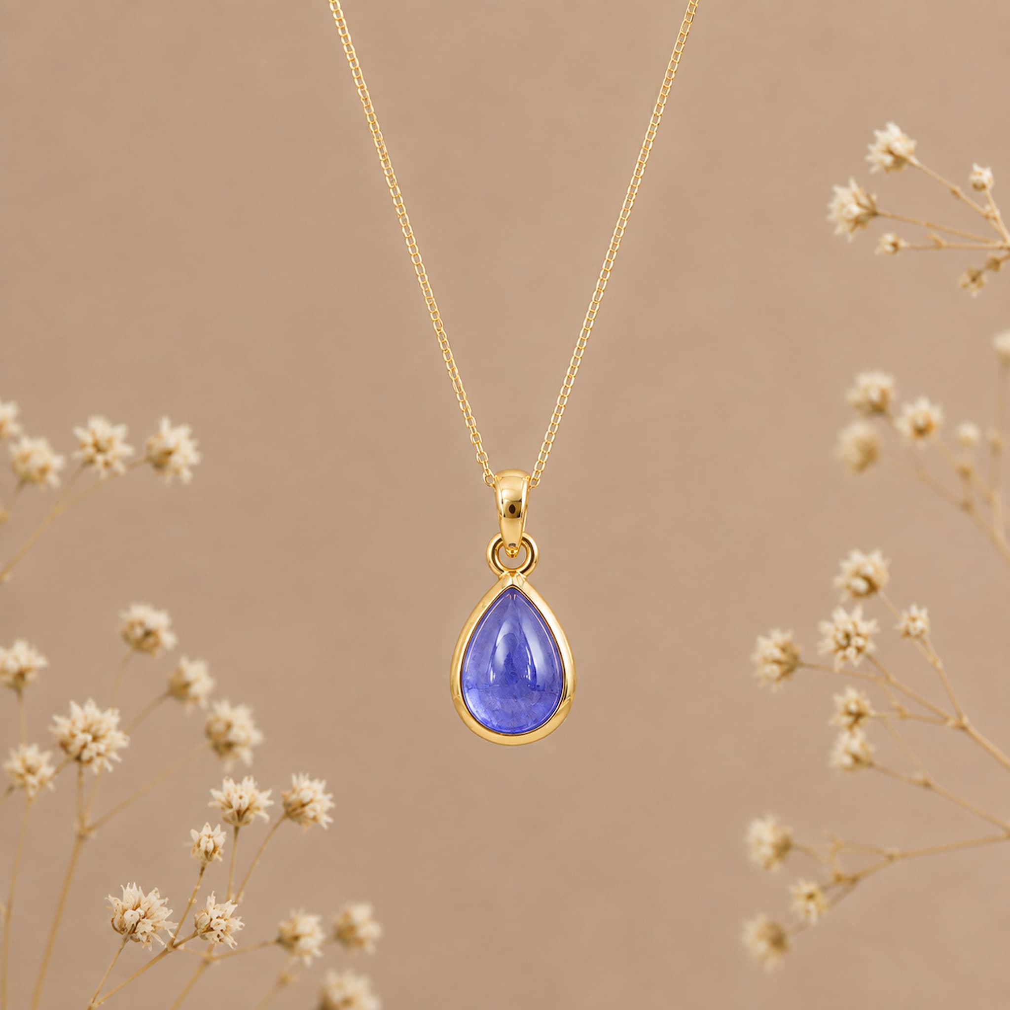 Birthstone necklace by Indie and Harper featuring a purple teardrop tanzanite pendant on a gold chain