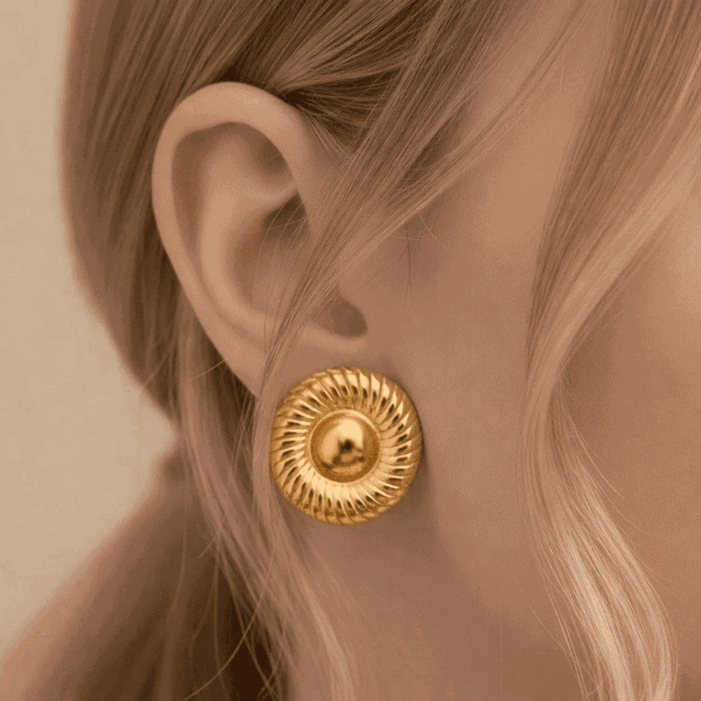 Gold earring worn by a person with blonde hair.