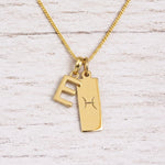 gold initial e pendant and pisces zodiac star sign pendant on a fine gold chain