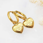 waterproof stainless steel gold evil eye heart charm huggie earrings on a white background