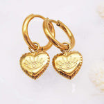 Waterproof Stainless Steel Gold Evil Eye Heart Charm Huggie Earrings on a white surface