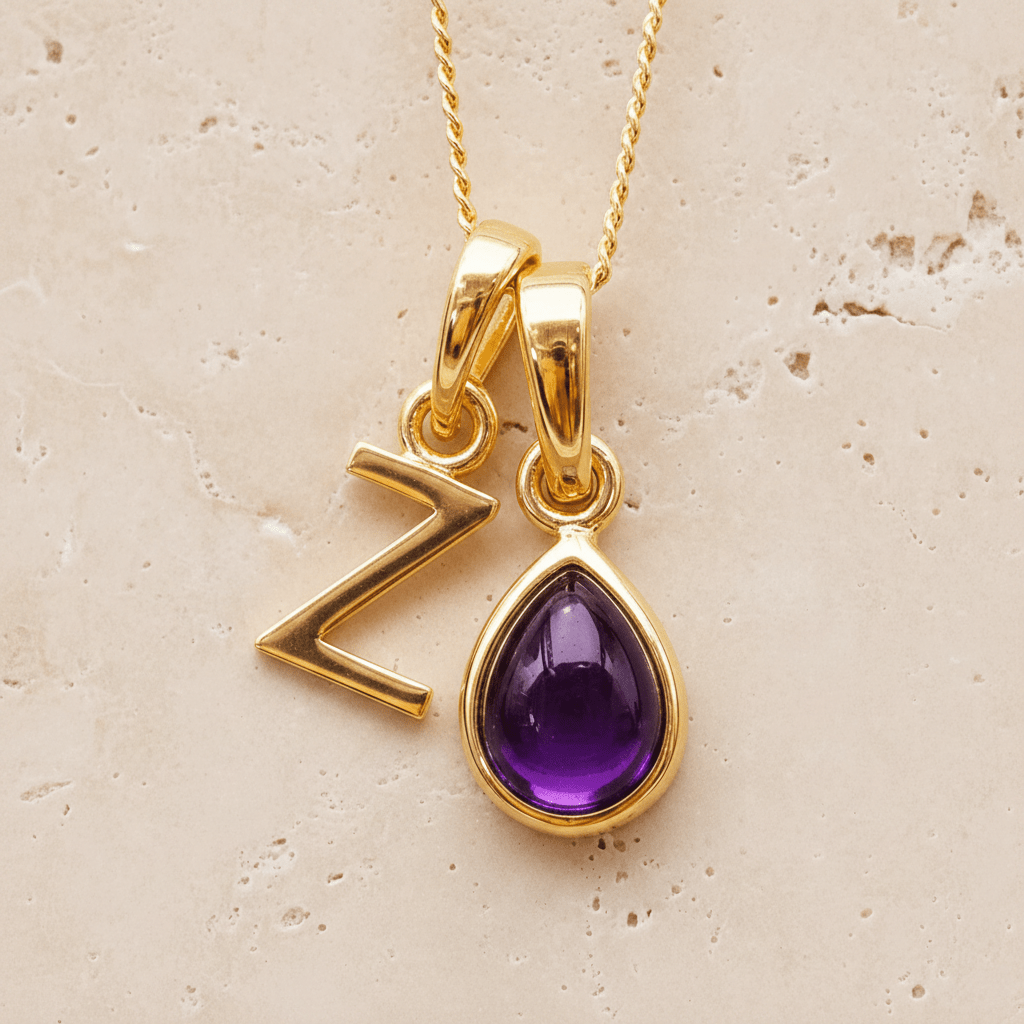 Gold double pendant necklace with a february birthstone purple teardrop amethyst gemstone pendant and letter 'Z' charm on a beige background