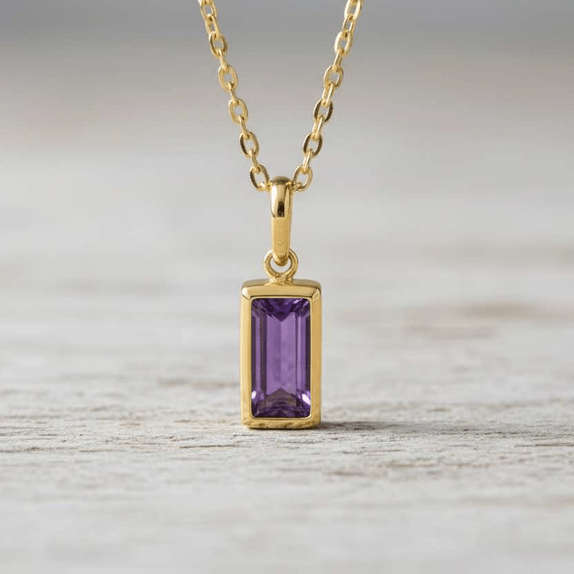 Gold necklace with a purple gemstone pendant on a white background