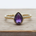 Gold February Birthstone Ring with a pear-shaped natural amethyst gemstone as a meaningful birthstone jewellery gift for her
