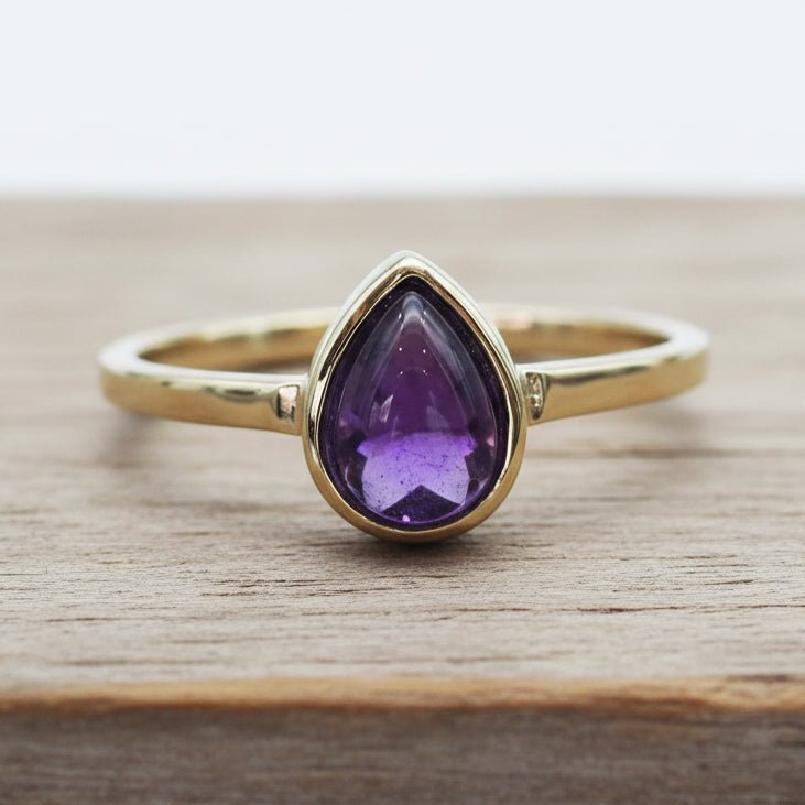 Gold February Birthstone Ring with a pear-shaped natural amethyst gemstone as a meaningful birthstone jewellery gift for her