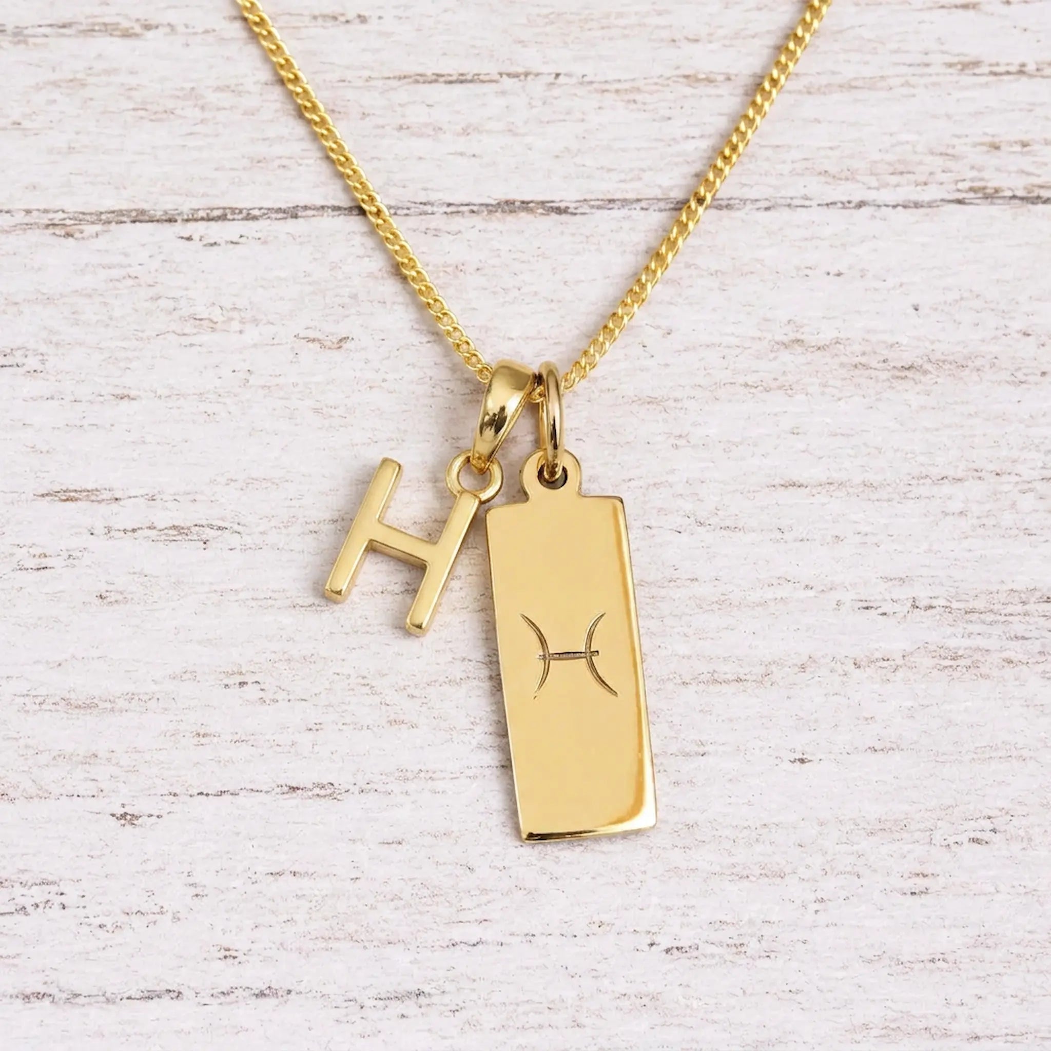 gold initial c pendant and pisces zodiac star sign pendant on a fine gold chain