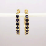 dainty gold huggie earrings with black cubic zirconias