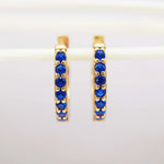dainty Gold huggie earrings with blue cubic zirconias