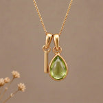 Gold Initial I Pendant and August birthstone Natural Peridot Necklace against a warm background