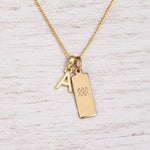 Gold Initial and Aquarius Zodiac Necklace with letter A pendant on light wood