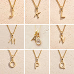 Gold fine chain necklaces with letters A and J to Q on a beige background as personalised Gold Initial Pendant options for April Birthstone Necklace.