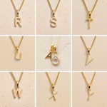 Gold fine chain necklaces with letters A and R to Y on a beige background as personalised Gold Initial Pendant options for April Birthstone Necklace.
