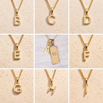 Collection of gold fine chain necklaces with gold letter pendants A to I, as personalised initial charms for Aquarius Zodiac Necklace on a beige background