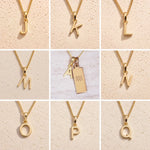 Collection of gold fine chain necklaces with gold letter pendants J to Q, as personalised initial charms for Aquarius Zodiac Necklace on a beige background