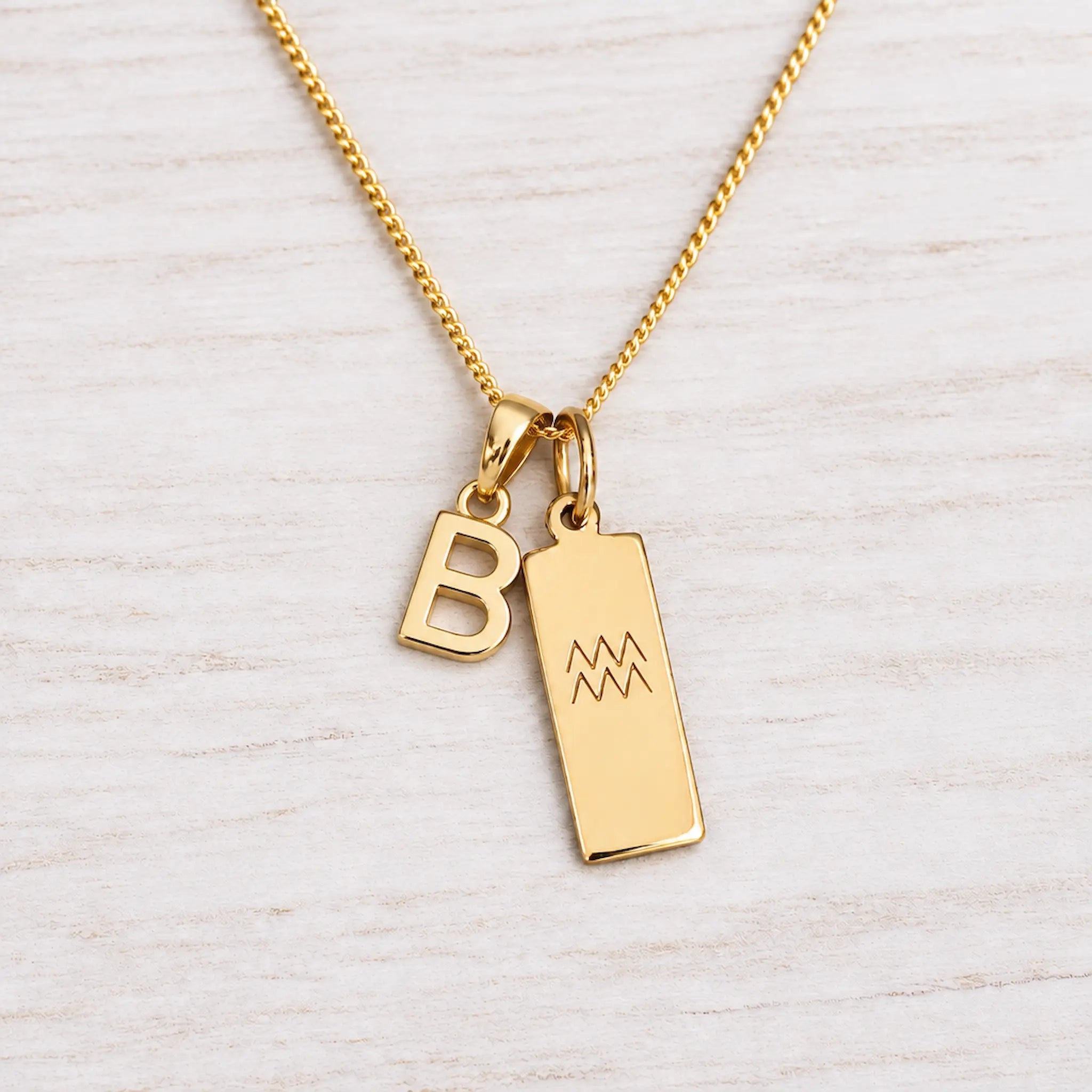 Gold Initial and Aquarius Zodiac Necklace with letter B pendant on light wood