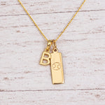 Gold Initial and Cancer Zodiac Necklace with letter B pendant on light wood