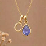 Gold Initial c and December Birthstone natural Tanzanite Necklace on a warm background