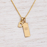Gold Initial and Aquarius Zodiac Necklace with letter D pendant on light wood