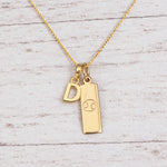 Gold Initial and Cancer Zodiac Necklace with letter D pendant on light wood