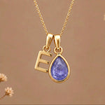 Gold Initial E and December Birthstone natural Tanzanite Necklace on a warm background
