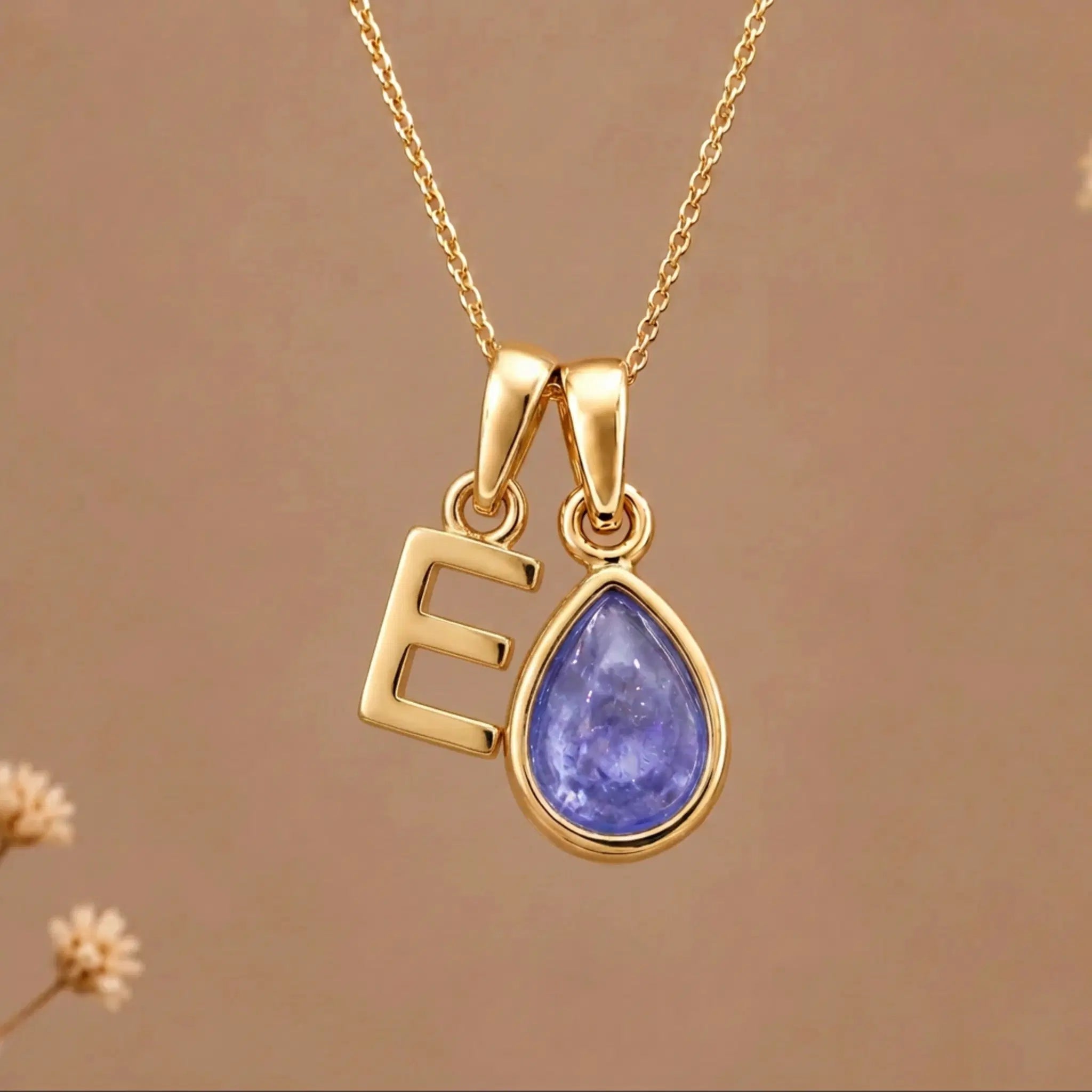 Gold Initial E and December Birthstone natural Tanzanite Necklace on a warm background