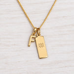 Gold Initial and Aquarius Zodiac Necklace with letter F pendant on light wood