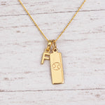 Gold Initial and Cancer Zodiac Necklace with letter F pendant on light wood