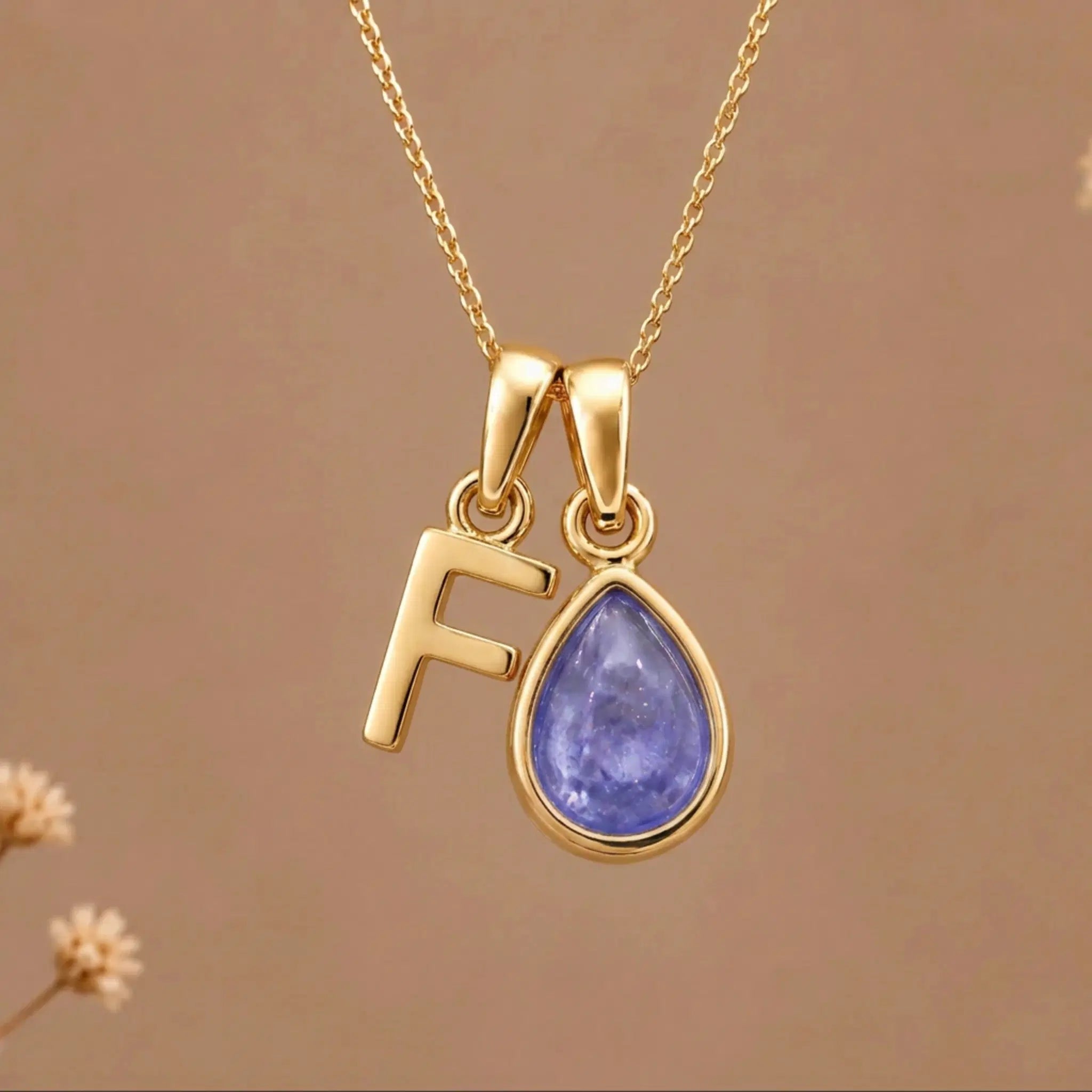 Gold Initial F and December Birthstone natural Tanzanite Necklace on a warm background