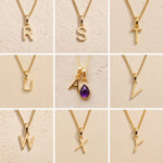 Gold chain necklaces with letter pendants R to Y on a beige background, as personalised gold letter options for the Gold February Birthstone Amethyst Necklace.