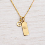Gold Initial and Aquarius Zodiac Necklace with letter G pendant on light wood