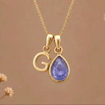 Gold Initial g and December Birthstone natural Tanzanite Necklace on a warm background