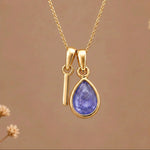 Gold Initial I and December Birthstone natural Tanzanite Necklace on a warm background