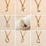 Collage of gold fine chain necklaces with various letters J to Q on a beige background as gold initial options for the January birthstone garnet necklace