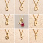 grid collection of gold fine chain necklaces with uppercase initial pendants B, C, D, E, A, F, G, H, I on a light background, as personalised options on a July Birthstone Ruby Necklace.