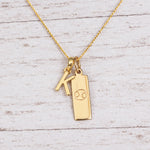 Gold Initial and Cancer Zodiac Necklace with letter K pendant on light wood
