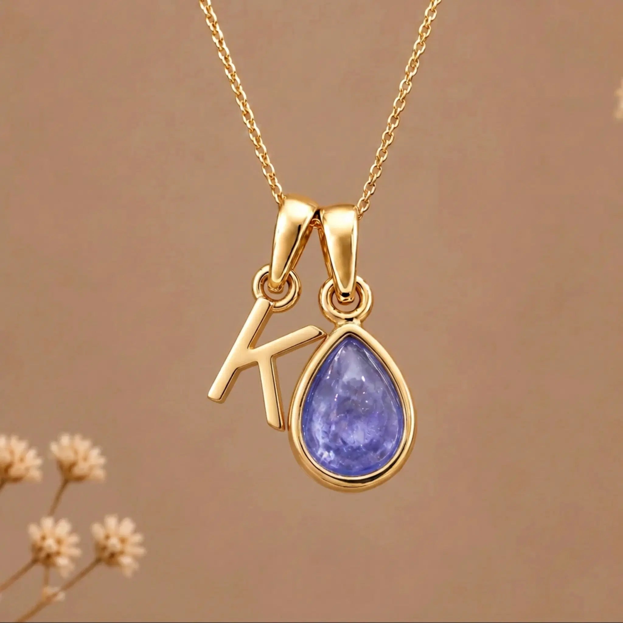 Gold Initial K and December Birthstone natural Tanzanite Necklace on a warm background