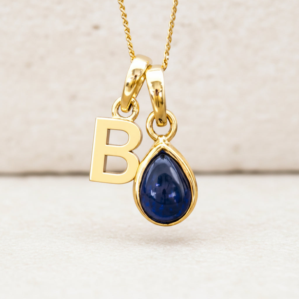 personalised Gold September birthstone necklace with 'B' initial pendant and blue sapphire teardrop gemstone 