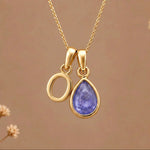 Gold Initial O and December Birthstone natural Tanzanite Necklace on a warm background