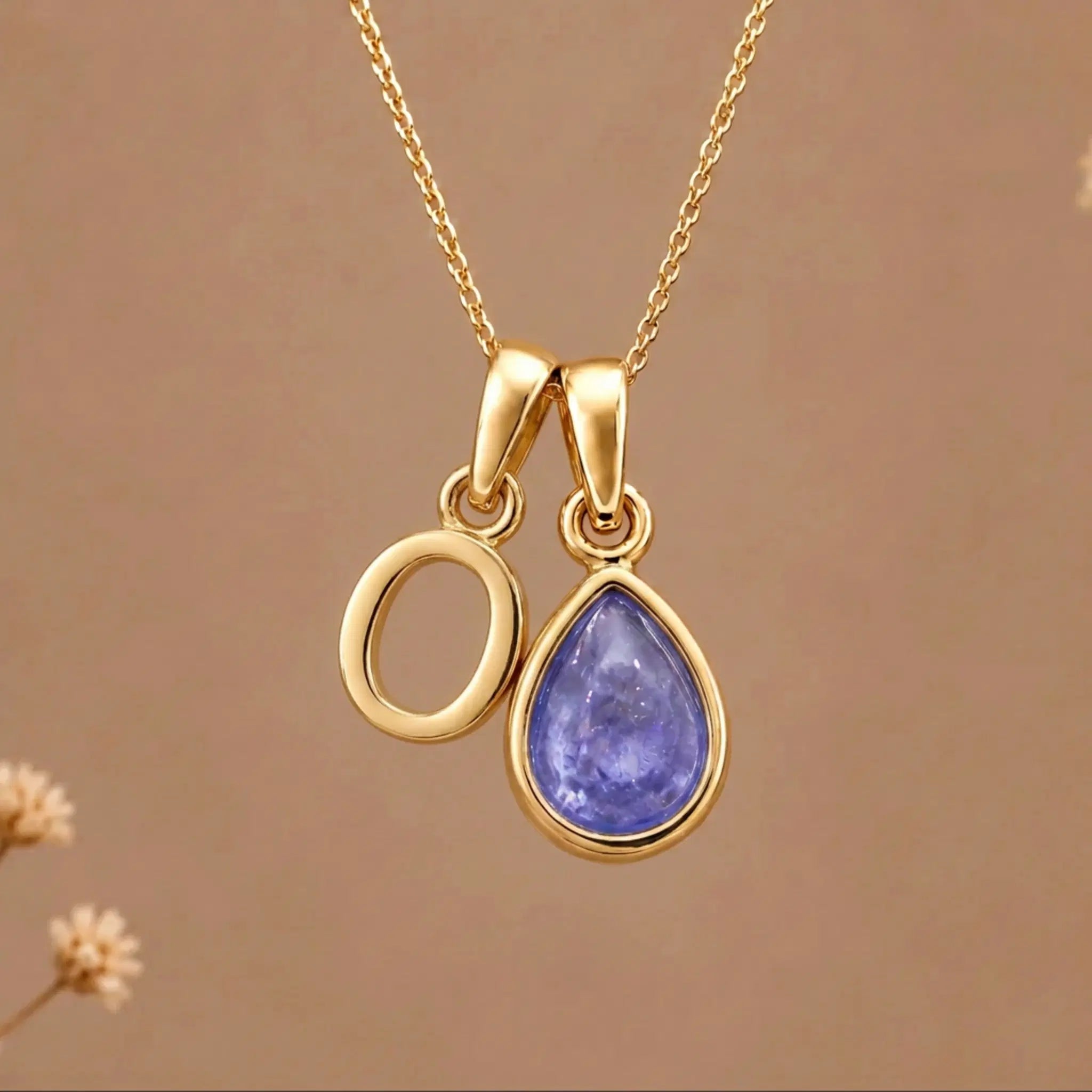 Gold Initial O and December Birthstone natural Tanzanite Necklace on a warm background