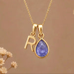 Gold Initial R and December Birthstone natural Tanzanite Necklace on a warm background