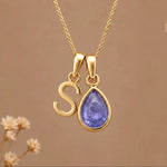 Gold Initial S and December Birthstone natural Tanzanite Necklace on a warm background