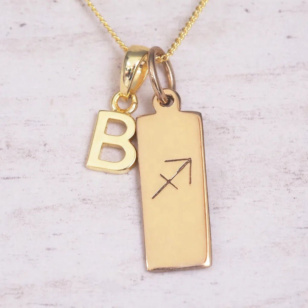 Gold 'B' initial necklace with Sagittarius Zodiac pendant on a light background.