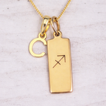 Gold necklace with two pendants on a light background