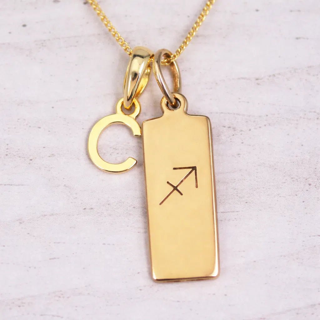 Gold 'C' initial necklace with Sagittarius Zodiac pendant on a light background.