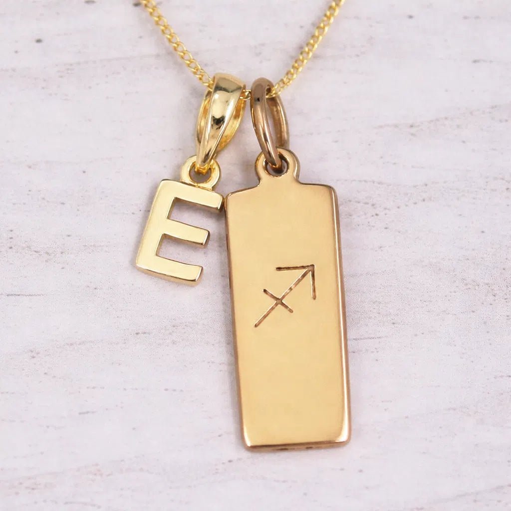 Gold 'E' initial necklace with Sagittarius Zodiac pendant on a light background.